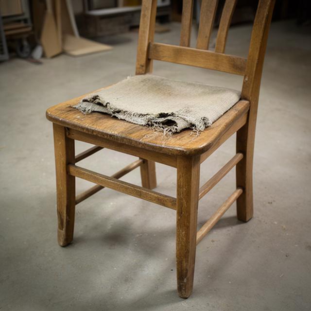 Sedia in legno con seduta rovinata prima del recupero